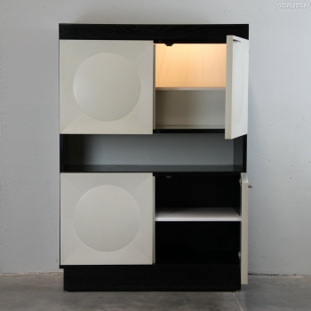 En hoja de roble ebonizada y madera lacada.
Diseño art óptico.
En la parte superior está el mueble bar con espejo, balda y luz.
Holanda.